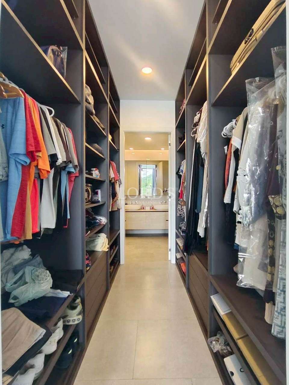 Narrow closet with organized clothing shelves