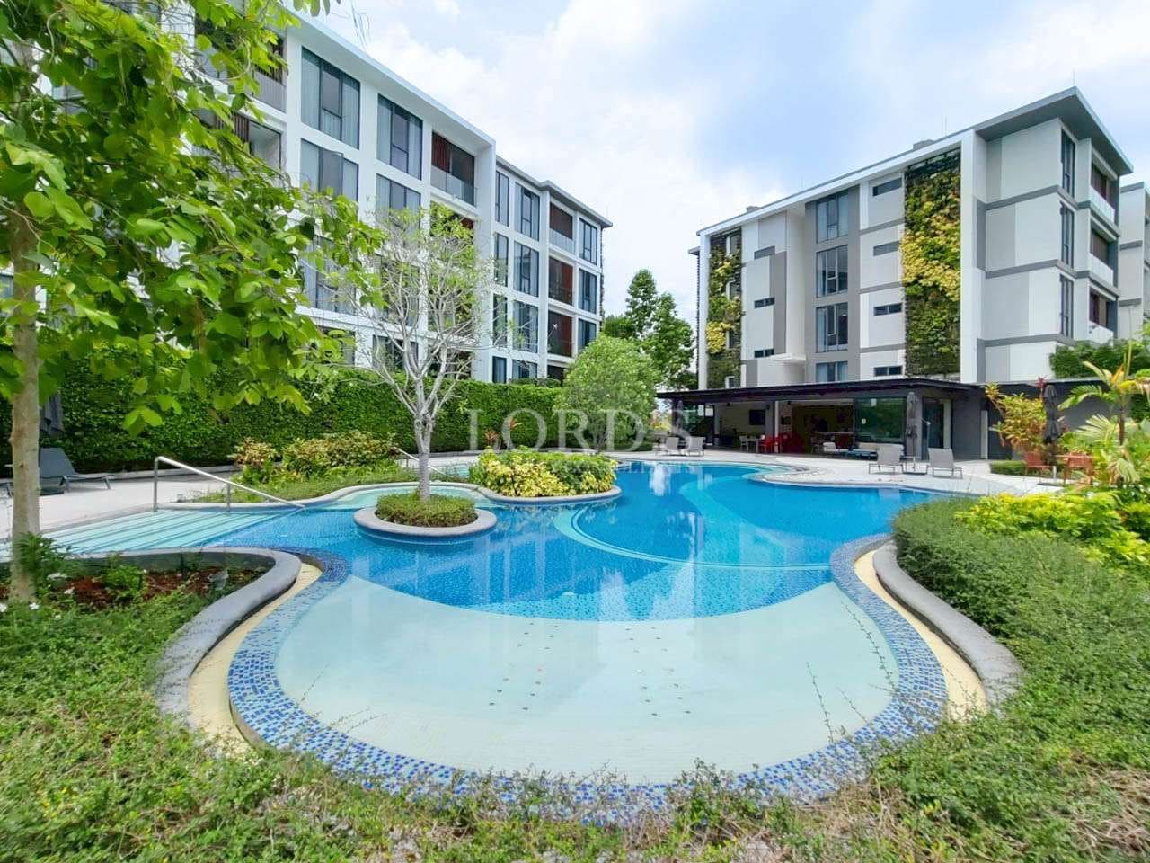 Modern poolside with lush greenery.