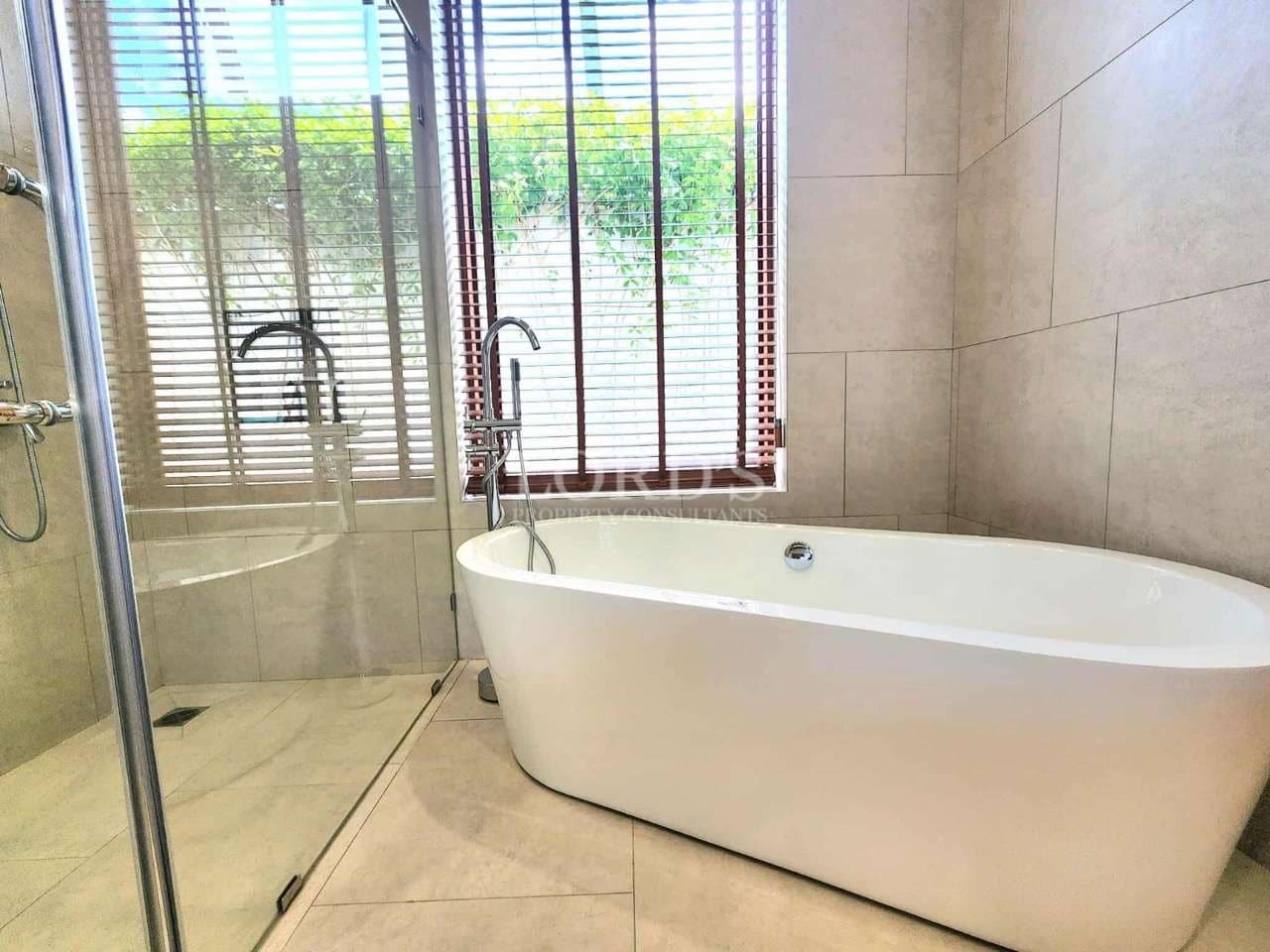 Modern bathroom with freestanding bathtub, glass walk-in shower, and large window with wooden blinds