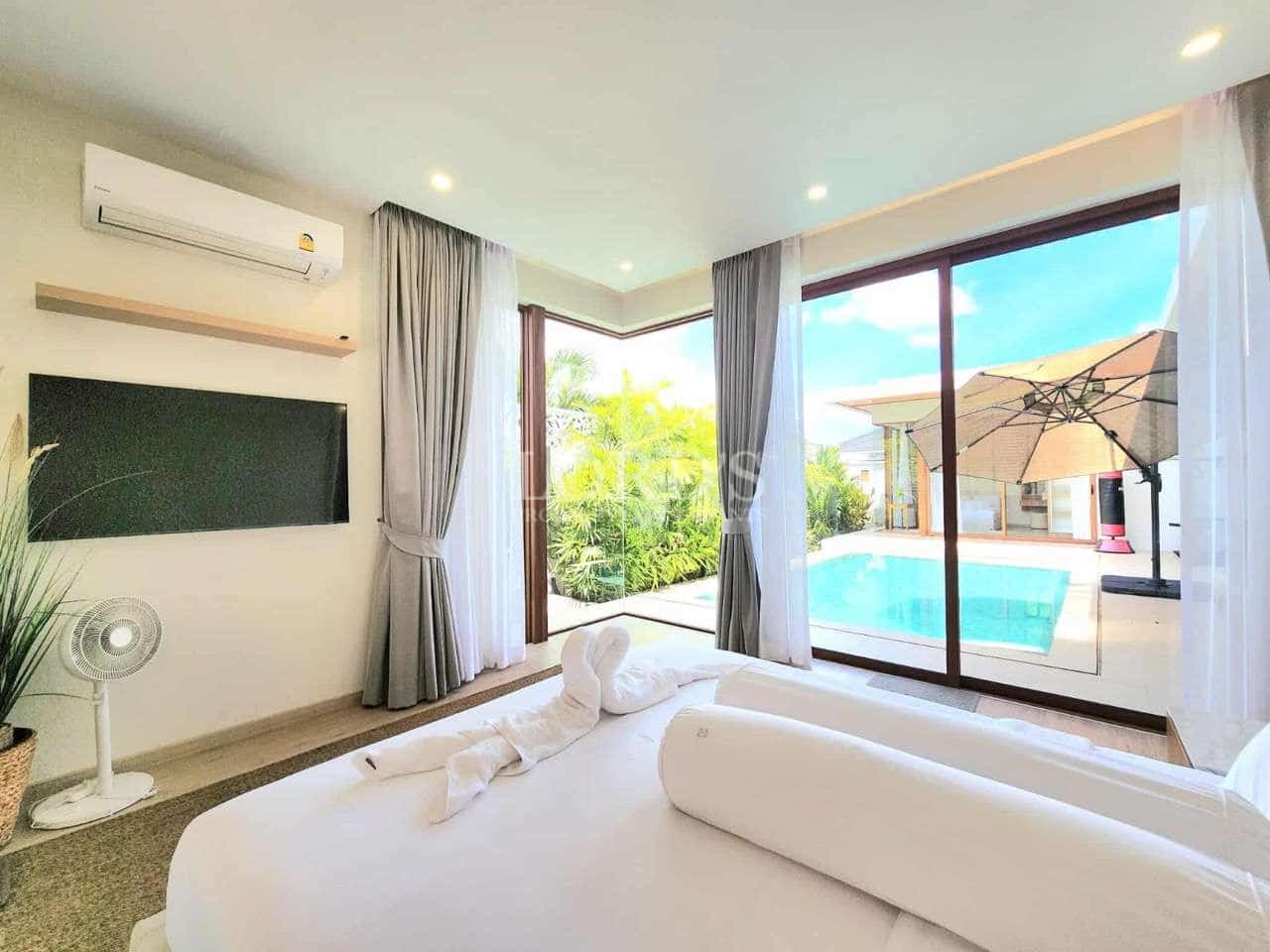Bright bedroom with pool view, large glass doors, air conditioning, and modern minimalist decor