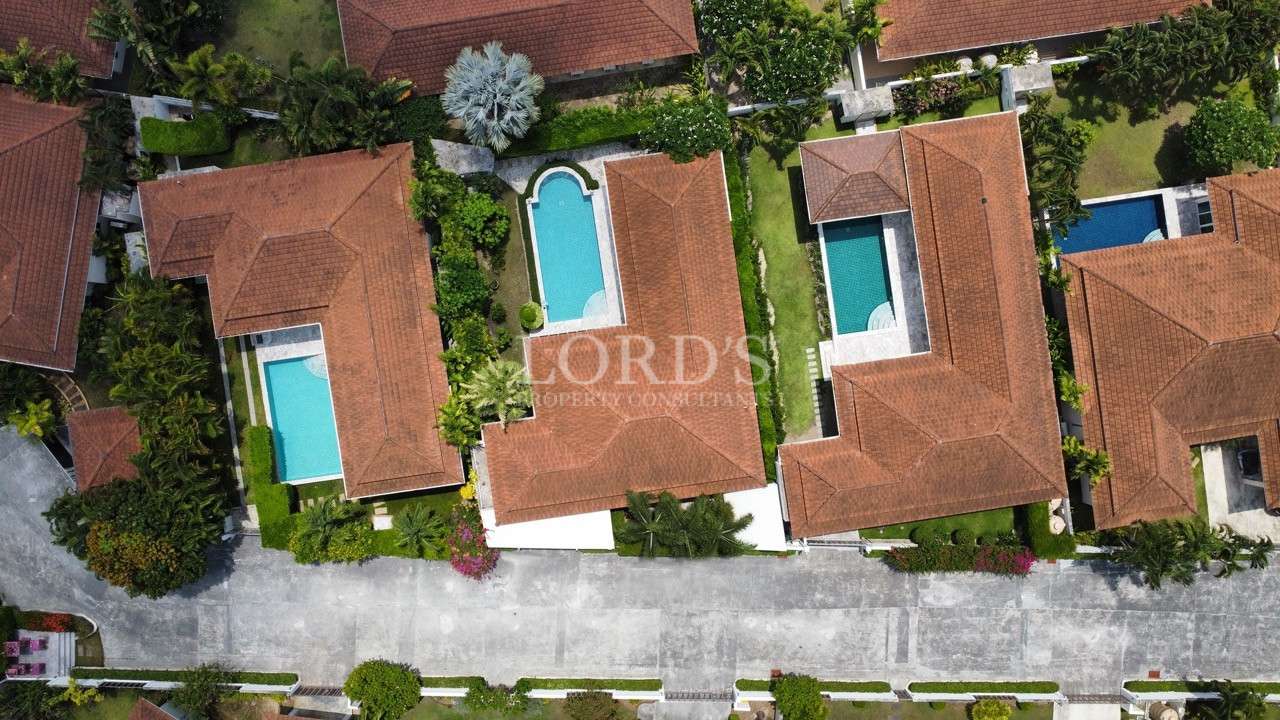 Aerial view of luxury villas with private swimming pools and tiled roofs