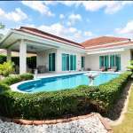 Luxury single-story villa with private swimming pool, garden hedges, and outdoor seating area.