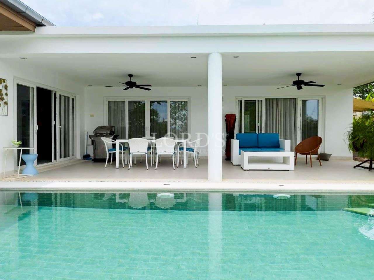 Modern villa with poolside seating.