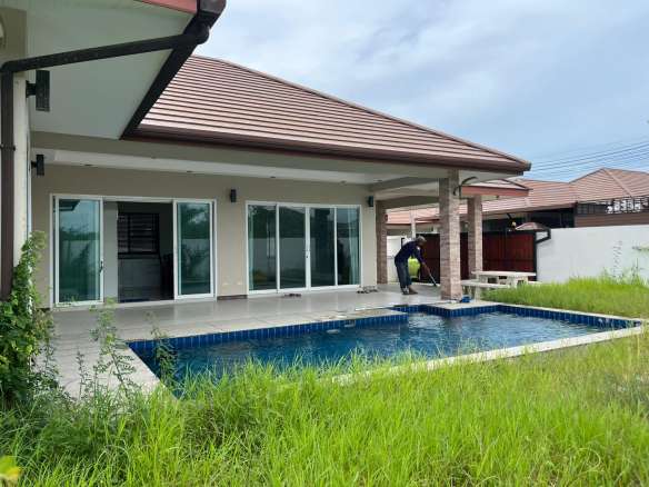 House with pool and overgrown grass