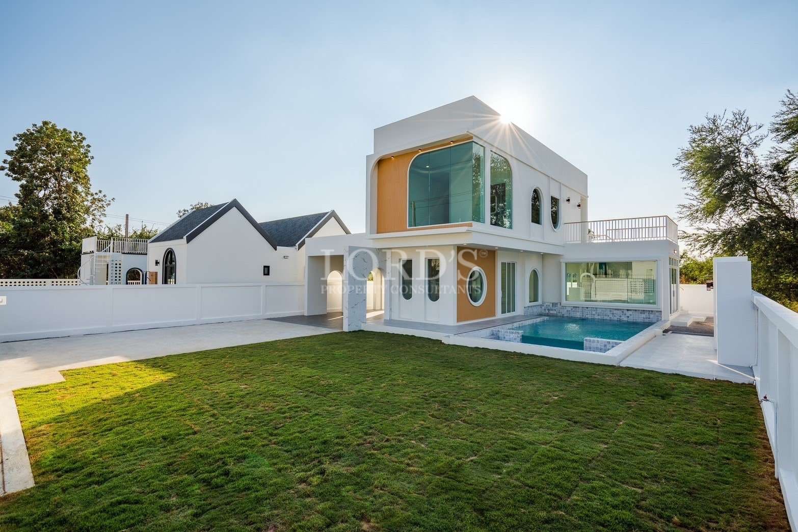 Modern luxury villa with private swimming pool, balcony, and landscaped lawn