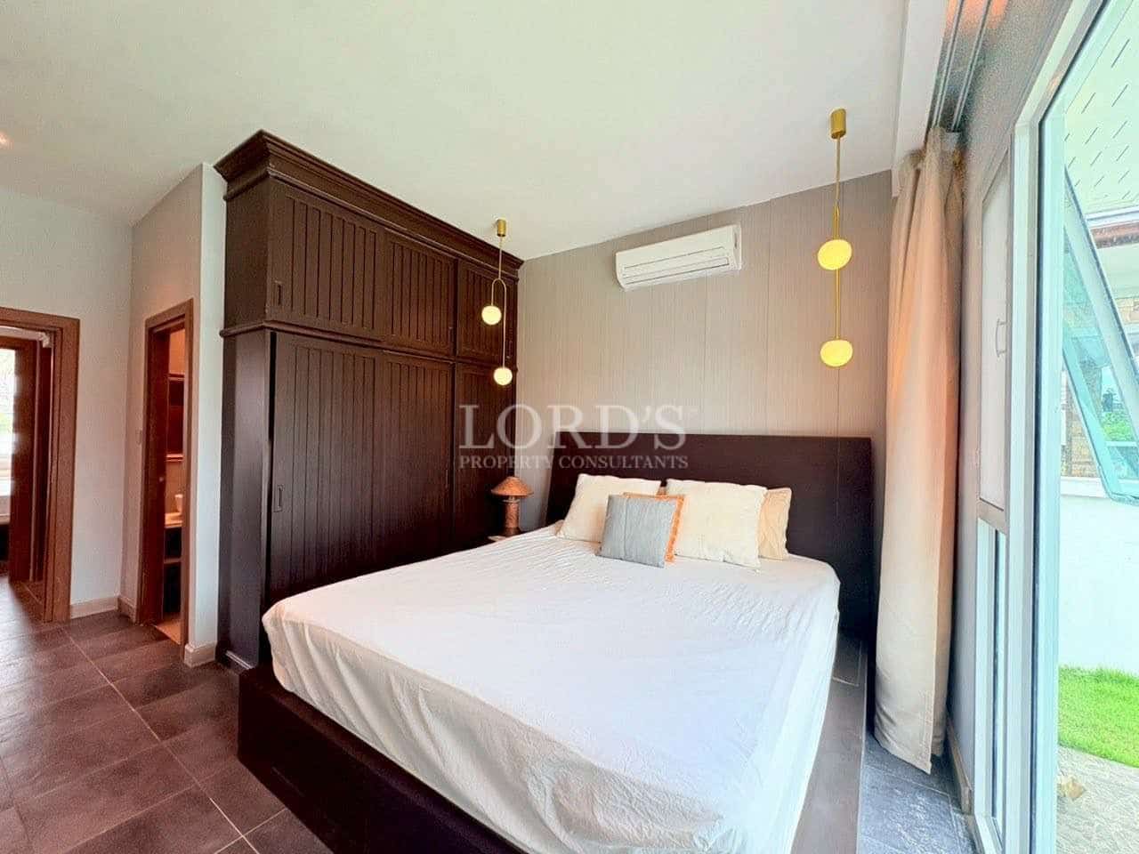 Modern bedroom with built-in dark wood wardrobe and glass sliding door