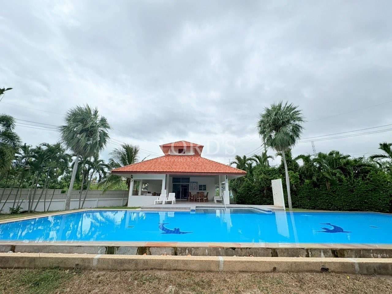 Large swimming pool with poolside pavilion and palm trees