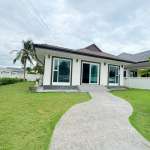 Modern single-story house with green lawn and curved walkway