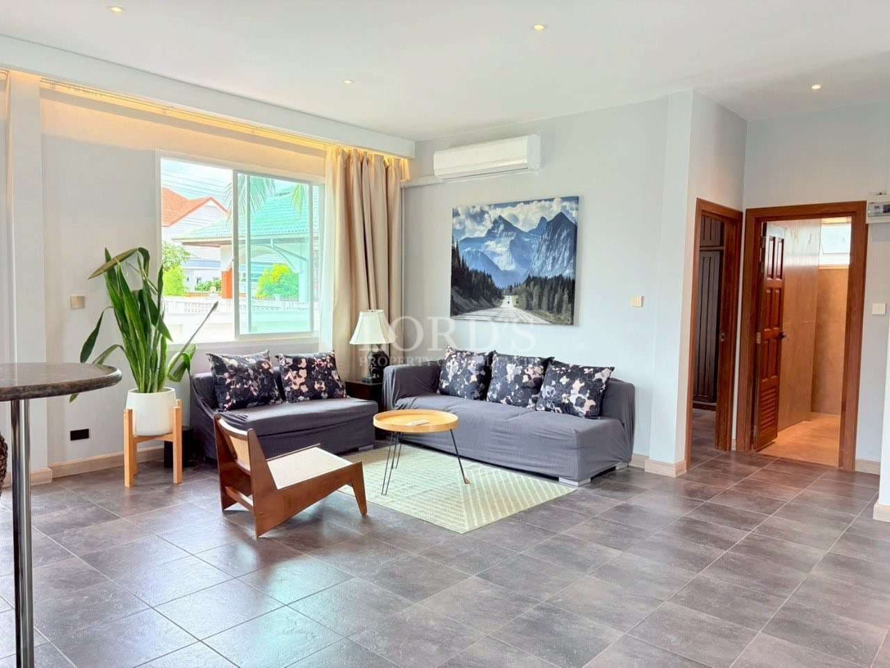 Modern living room with sectional sofa, wall art, and large window