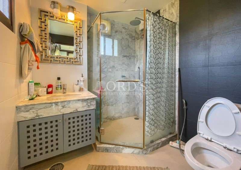 Modern bathroom with glass shower enclosure, marble vanity, and contemporary fixtures