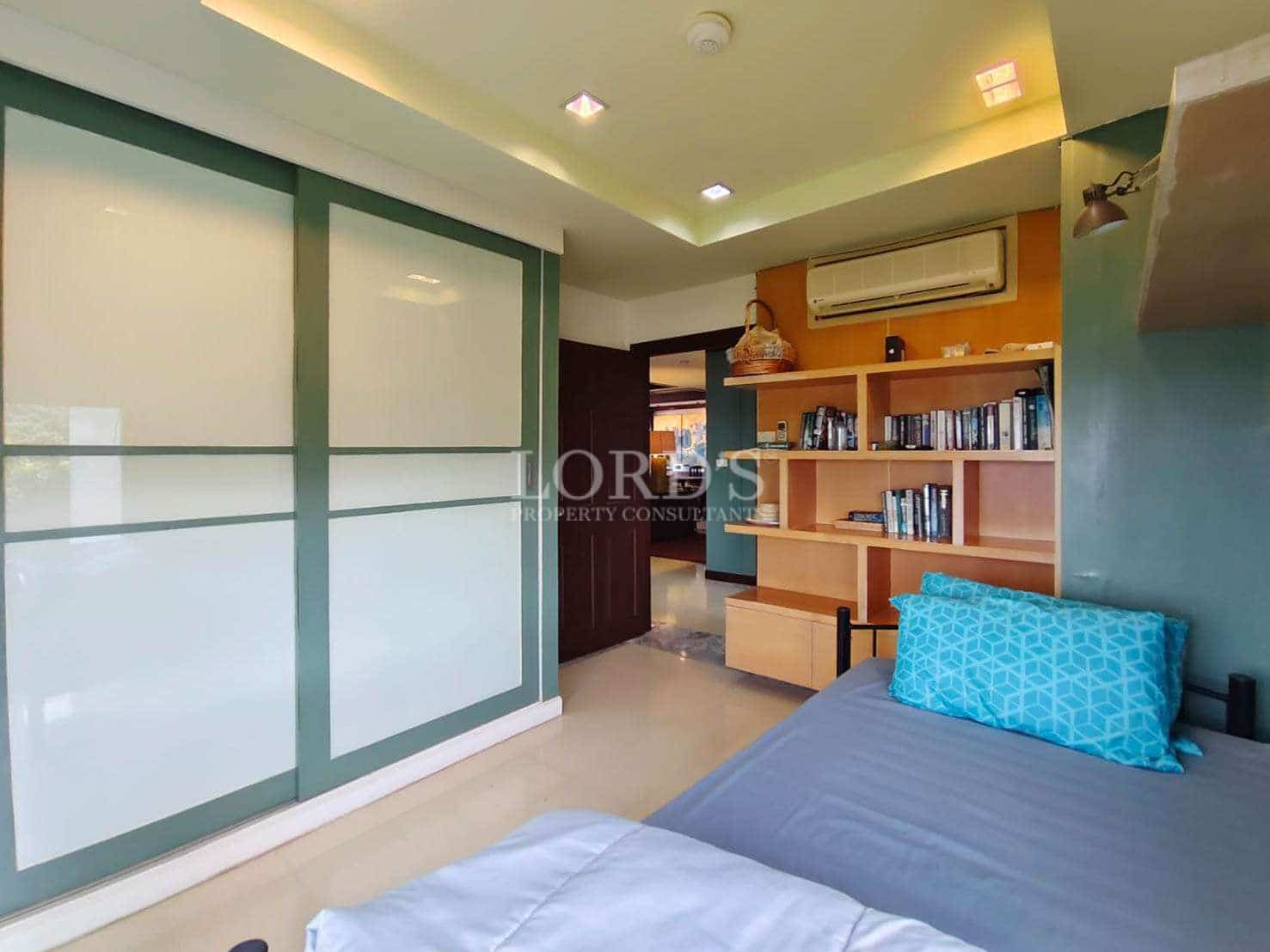 Modern bedroom with built-in wardrobe, open bookshelf, and minimalist interior design