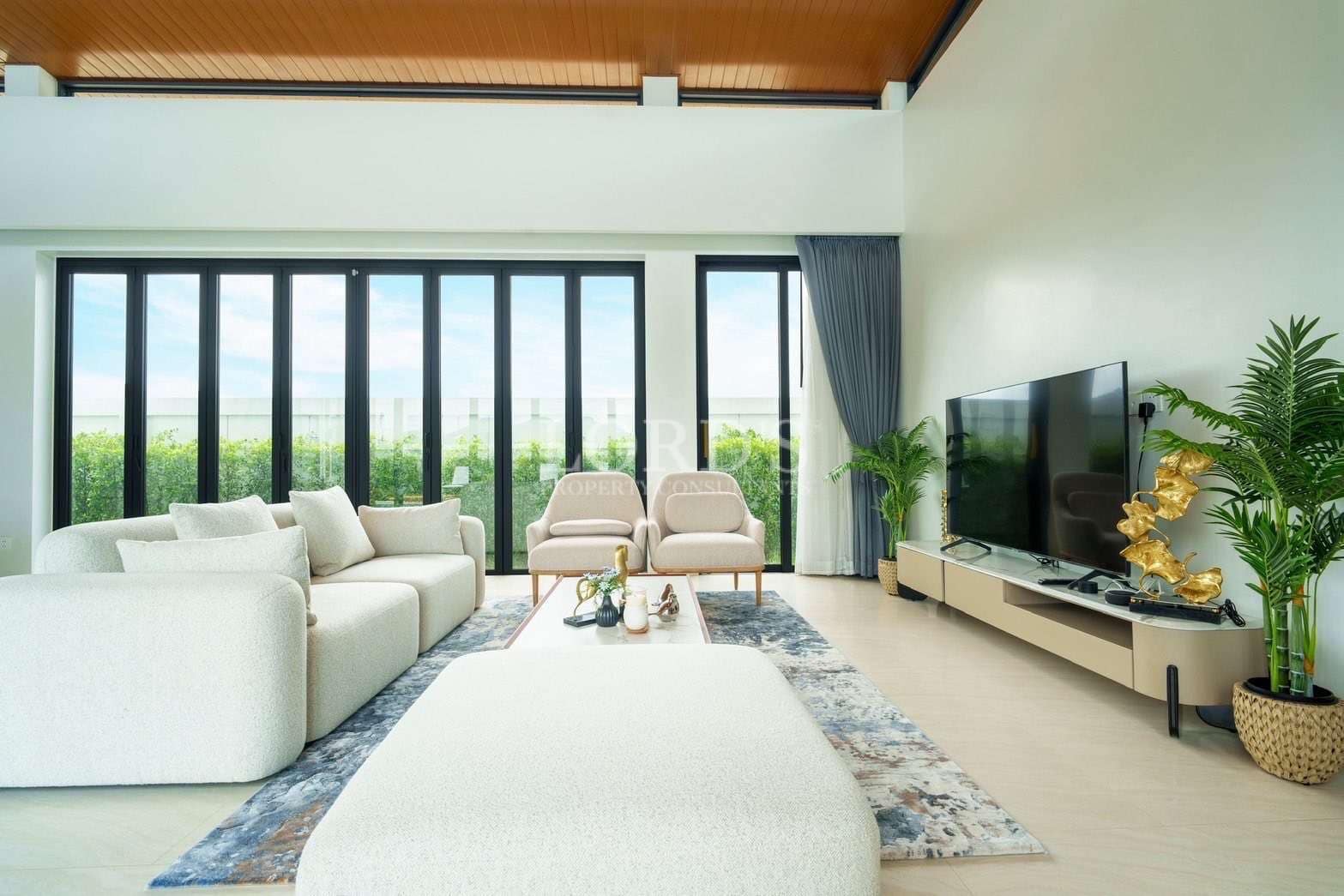 Luxury living room with modern sofa, armchairs, floor-to-ceiling windows, and minimalist TV unit.