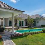 Modern luxury villa with private swimming pool, covered patio, and landscaped garden