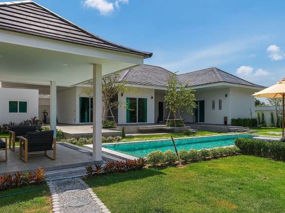 Modern luxury villa with private swimming pool, covered patio, and landscaped garden