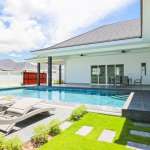 Luxury villa with private swimming pool, sun loungers, and landscaped garden