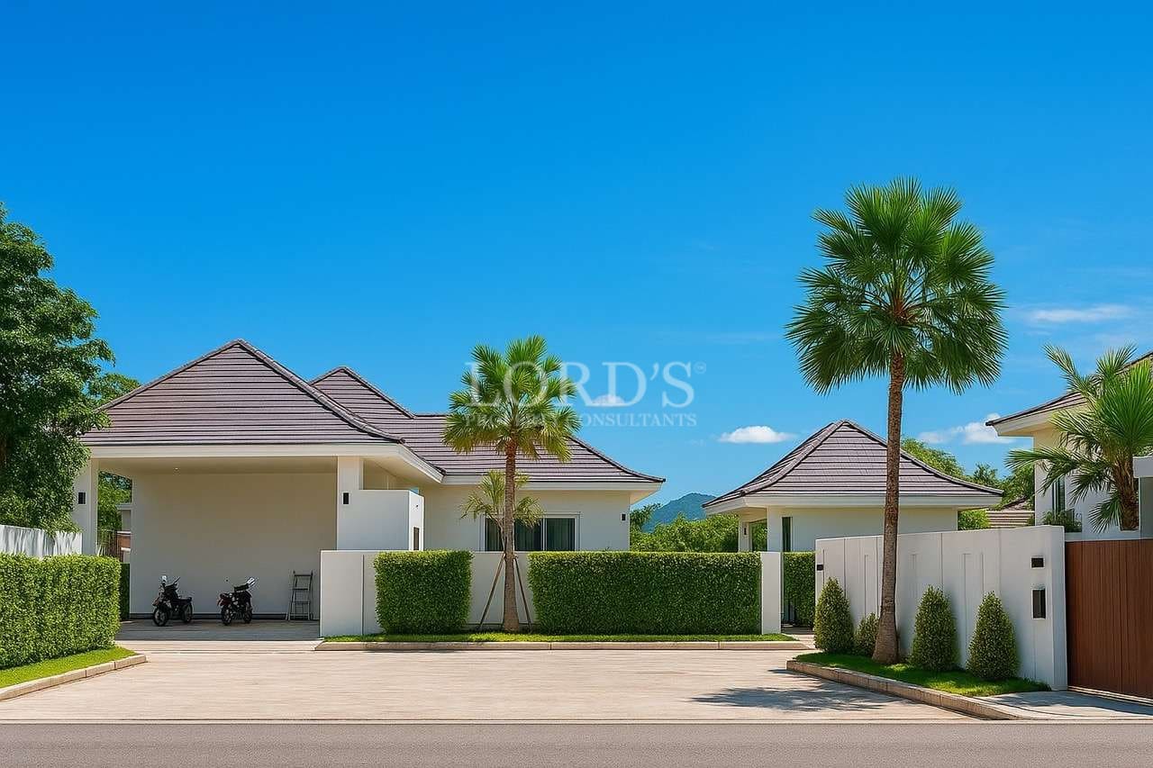 Modern luxury villa entrance with wide driveway, palm trees, and gated exterior