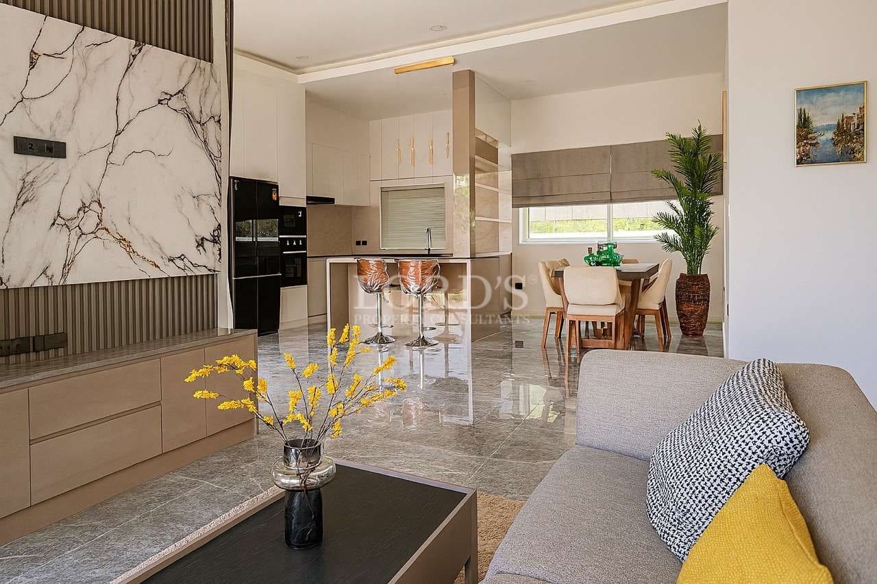 Modern open-plan living area with kitchen island, dining space, and contemporary interior design