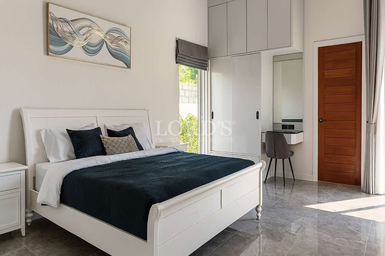 Modern bedroom with white bed frame, built-in wardrobe, and minimalist interior design