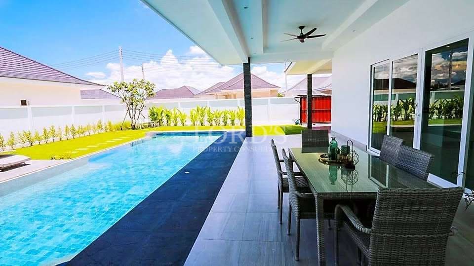 Modern villa with private swimming pool, covered patio, and outdoor dining area