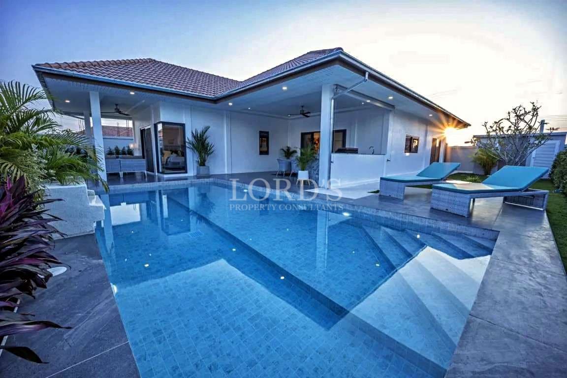 Luxury modern villa with private swimming pool at sunset and covered outdoor lounge