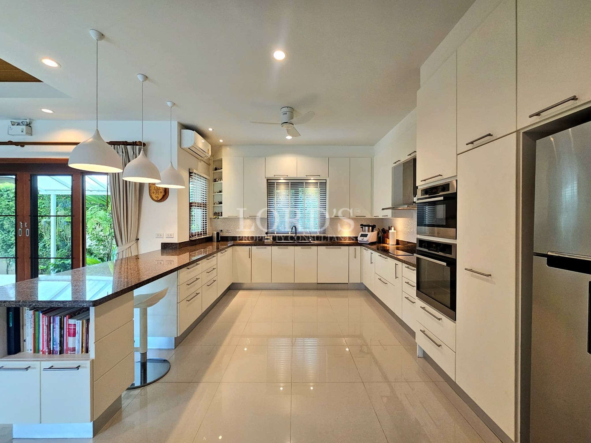 Modern white kitchen with built-in appliances and island counter