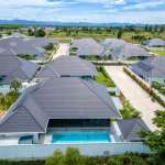 Aerial view of luxury villa community with private swimming pools, landscaped gardens, and mountain views