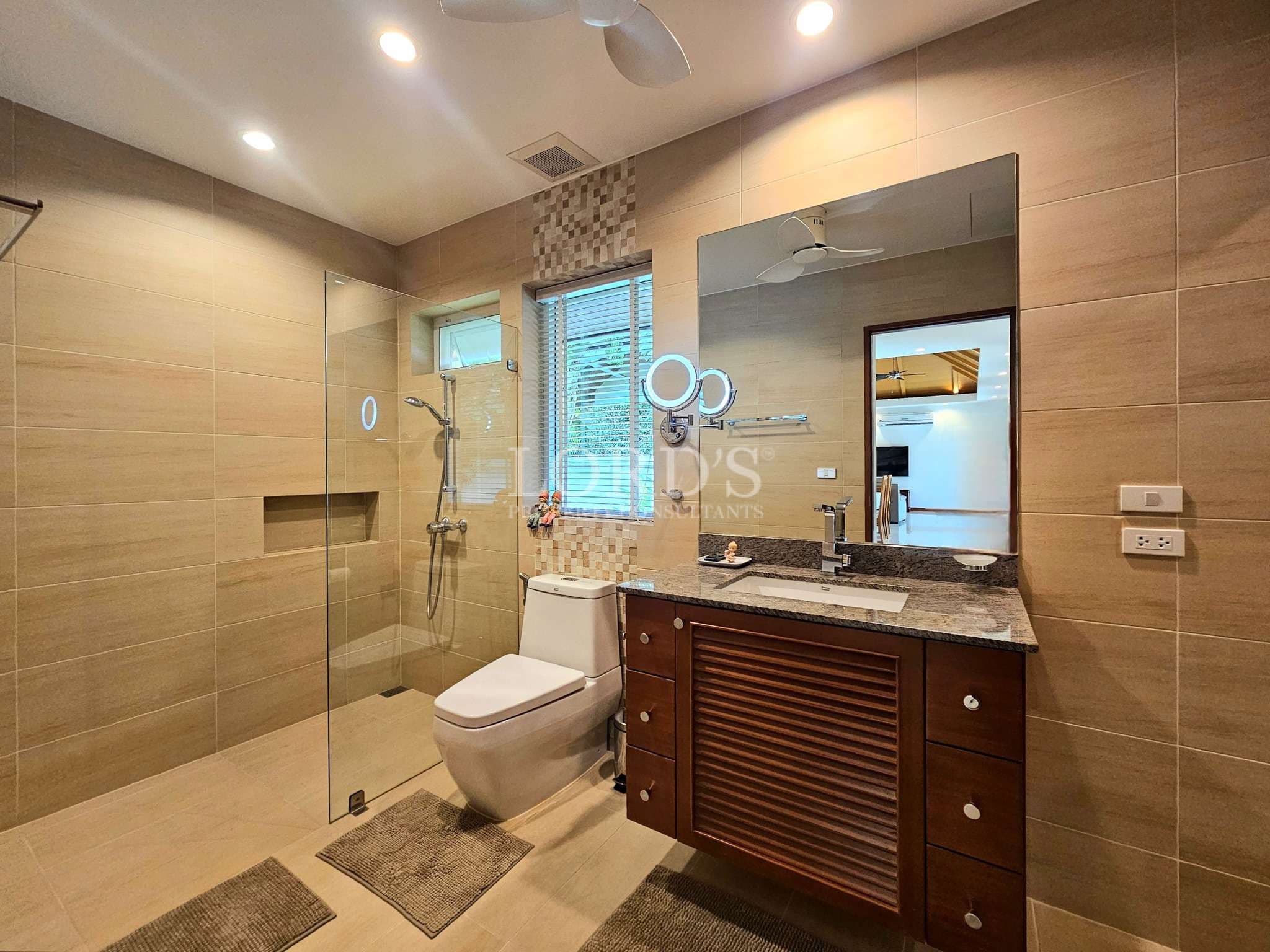 Modern bathroom with walk-in glass shower, vanity cabinet, and contemporary fixtures