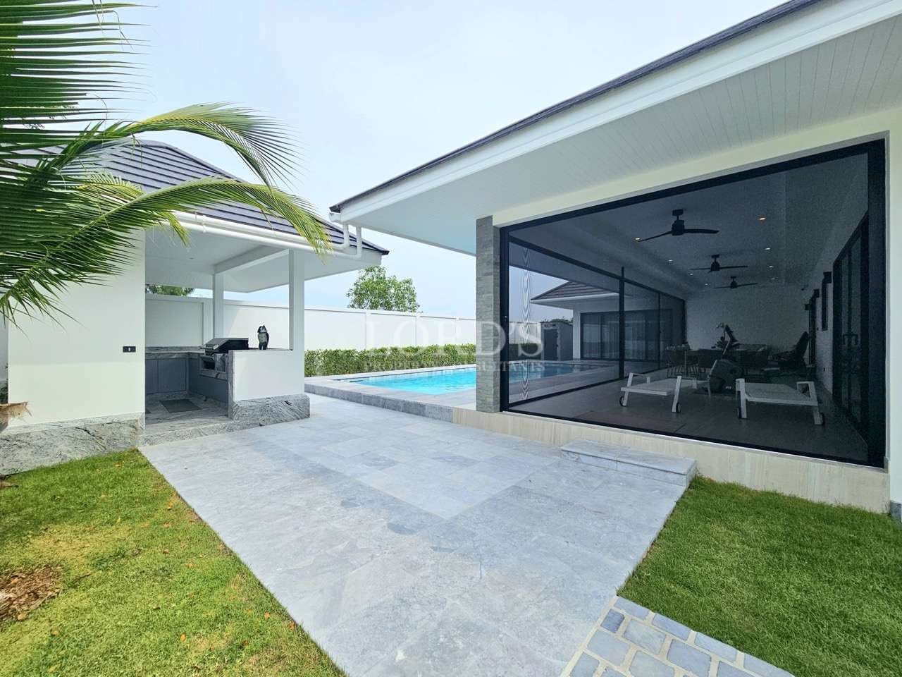 Modern villa outdoor area with private pool, covered patio, and open lounge space