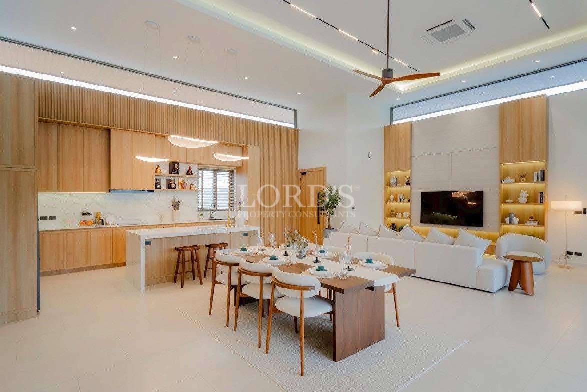 Luxury open-plan living, dining, and kitchen area with wood finishes and modern lighting.