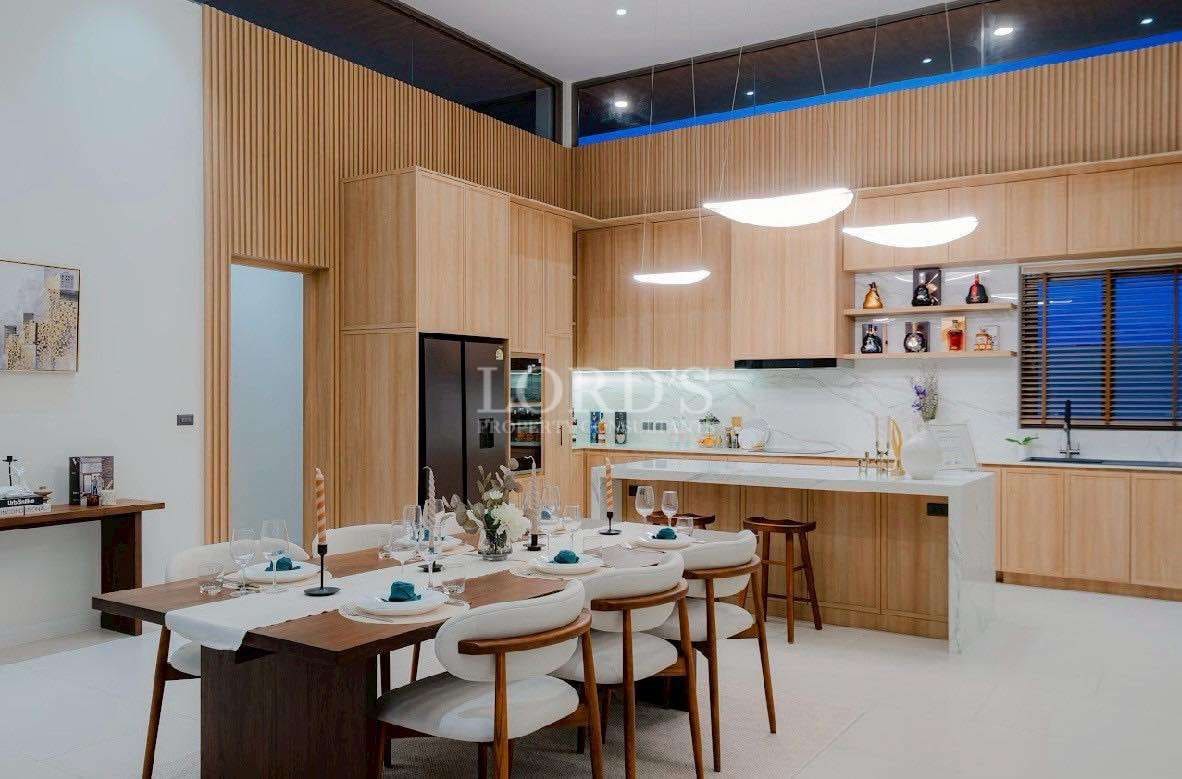 Luxury open-plan dining and kitchen area with wood finishes and modern island.