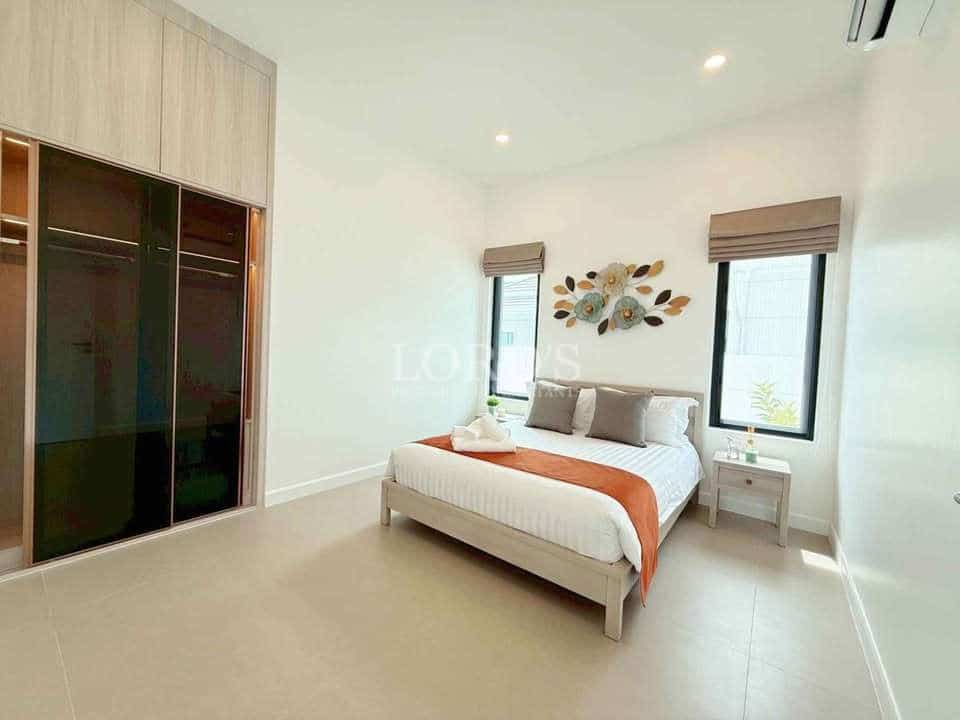 Minimalist bedroom with double bed, built-in wardrobe, neutral décor, and natural light.