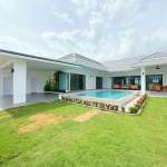 Modern single-story luxury villa with private swimming pool, landscaped lawn, and covered outdoor seating.