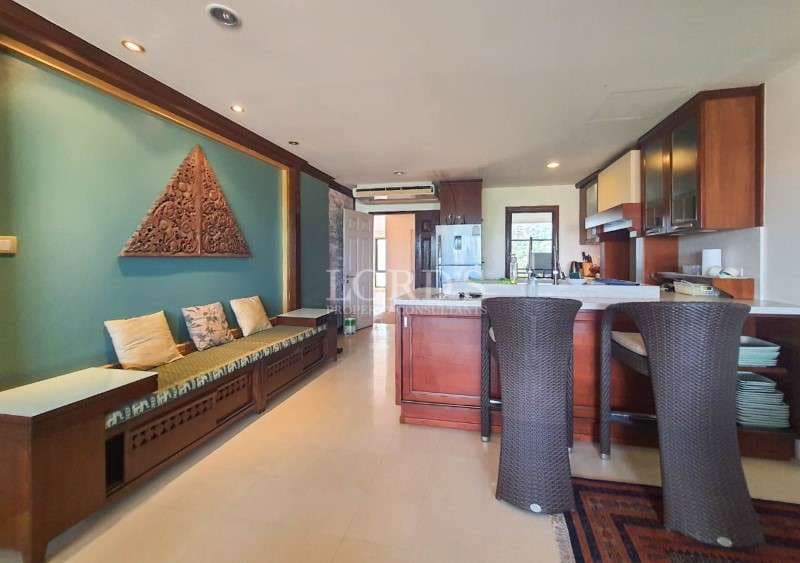 Open kitchen and dining area with wooden cabinets, breakfast bar, and seating bench