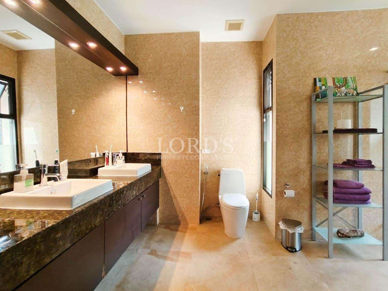 Luxury modern bathroom with double sink vanity, stone walls, and contemporary toilet design.
