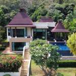 Luxury two-storey tropical villa with private swimming pool surrounded by lush greenery and hillside views.