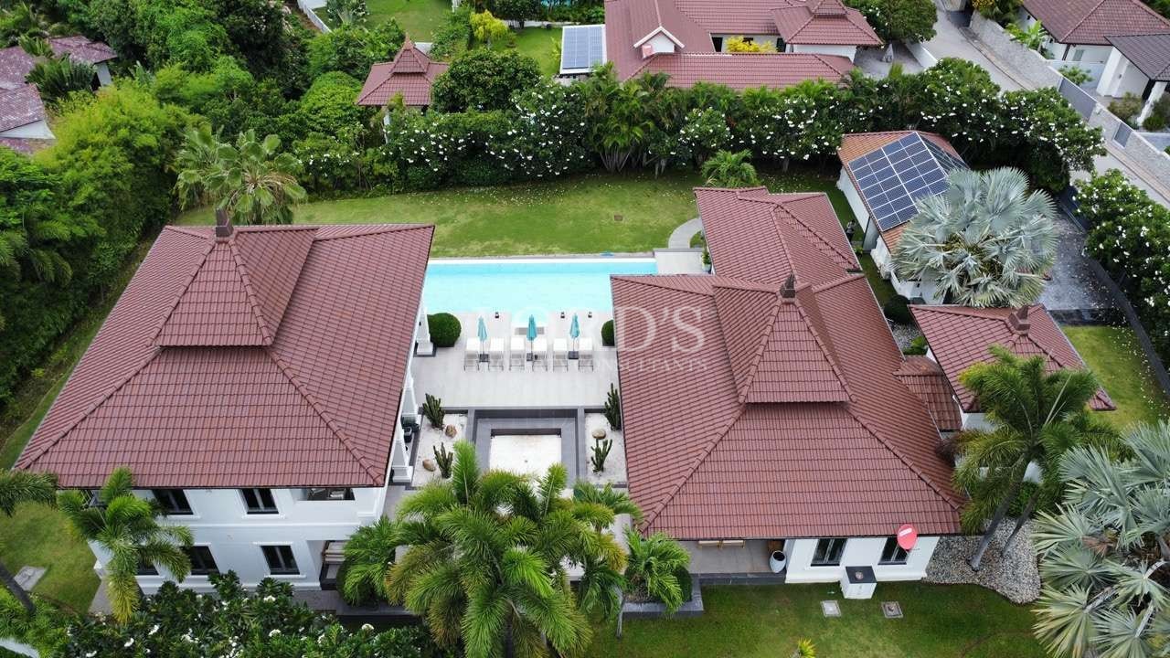 Aerial view of luxurious villas and pool.