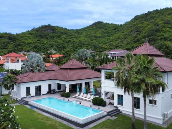 Luxurious villa with pool and greenery.