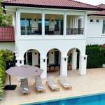Luxury two-story villa with private swimming pool, balcony, and poolside sun loungers.