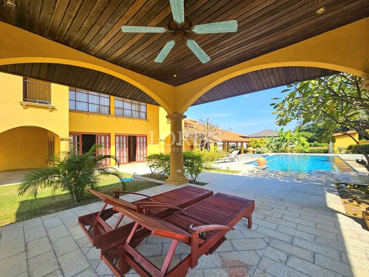 Sunny poolside view with lounge chairs