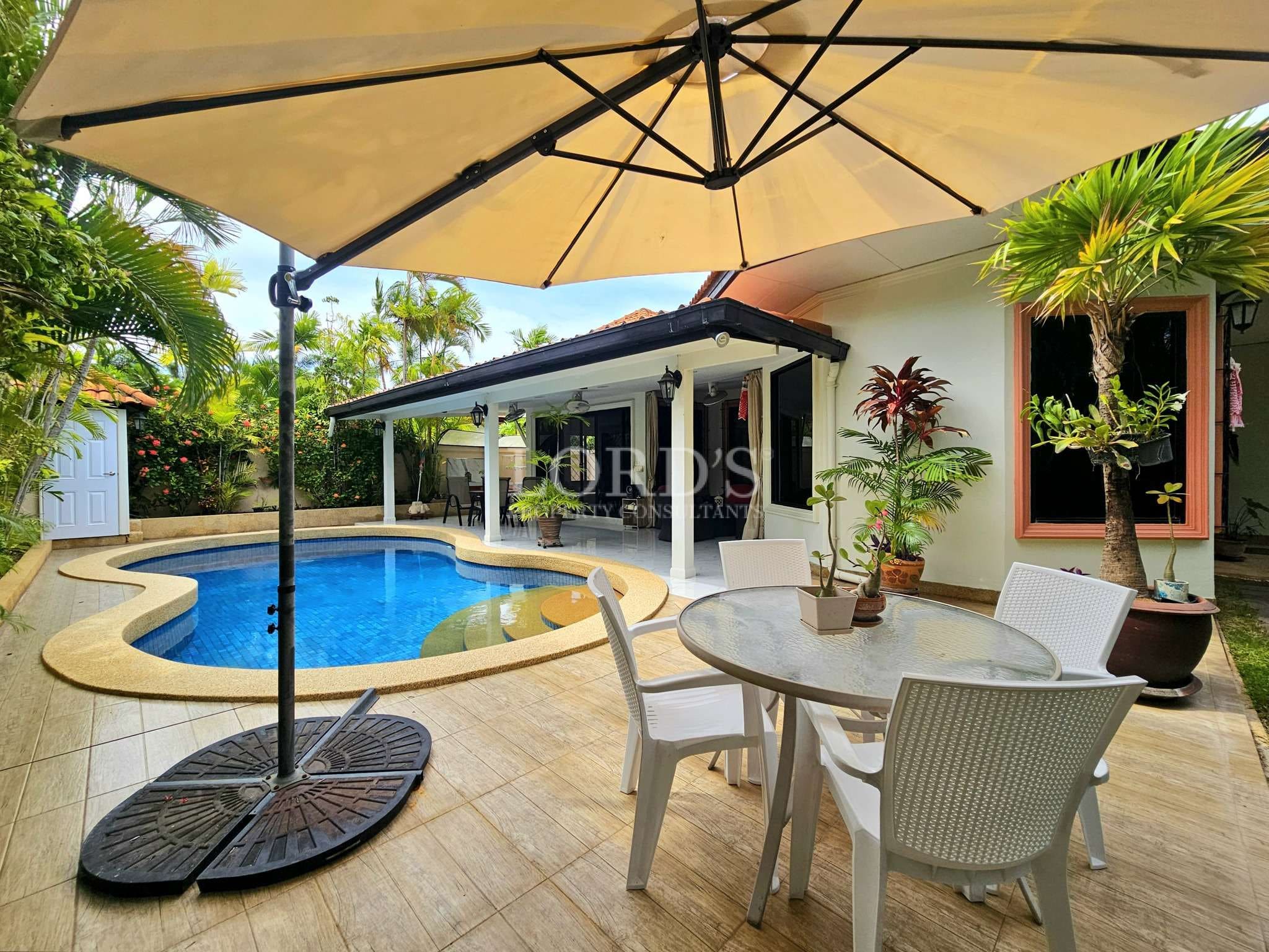 Poolside patio with umbrella and plants