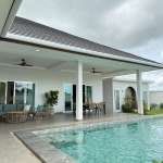 Luxury villa poolside patio with covered seating area, outdoor dining space, and private swimming pool.