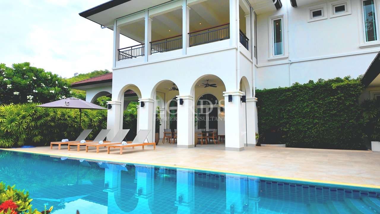 Luxury two-story villa with private swimming pool, arched terrace, and outdoor lounge area.