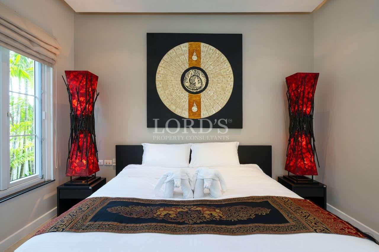 Luxury bedroom with king-size bed, Asian wall art, and red decorative floor lamps.
