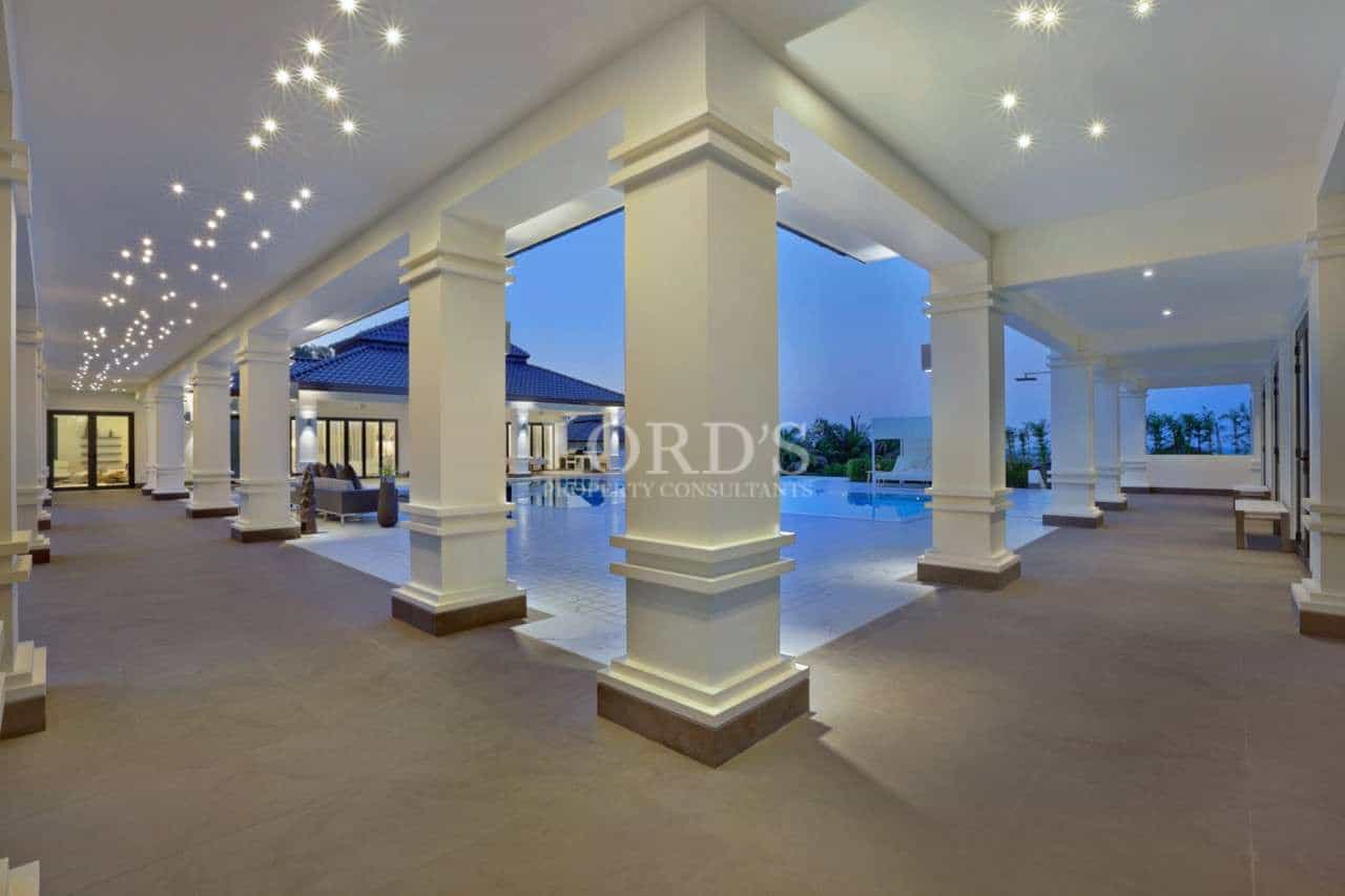 Elegant covered outdoor terrace with classical columns and ambient evening lighting.