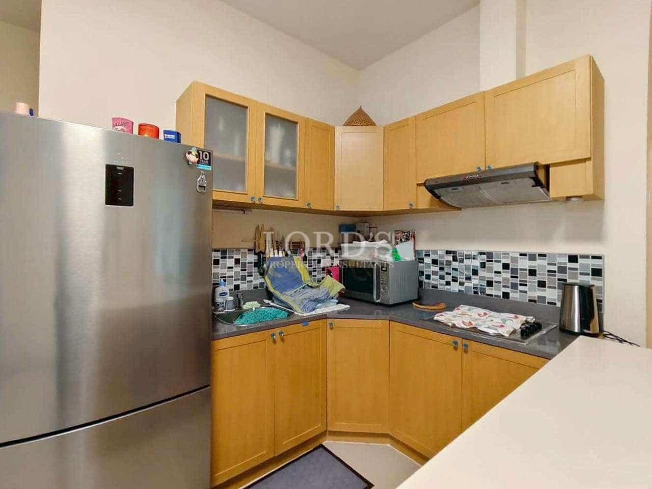 Compact kitchen with wooden cabinets.