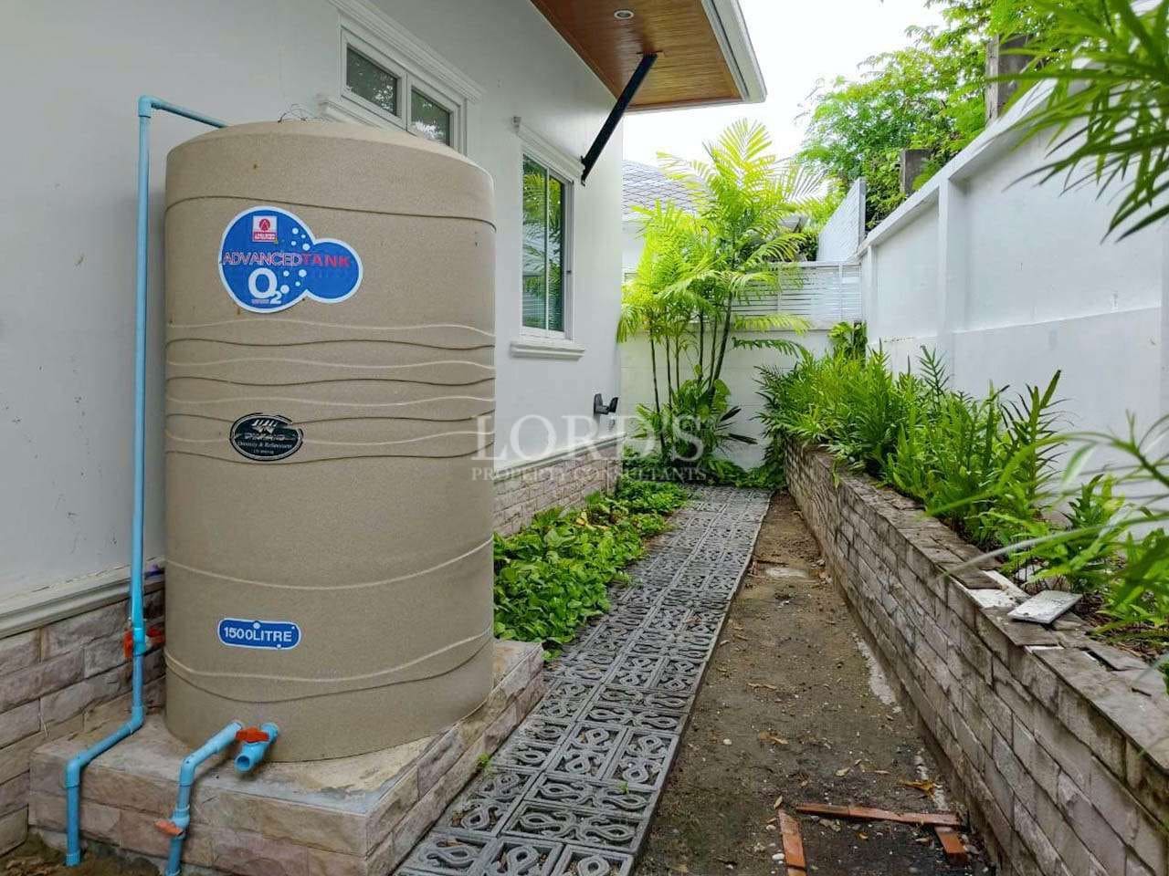 Water tank beside a garden pathway