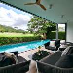 Covered poolside lounge with private swimming pool, outdoor seating, and scenic golf course views