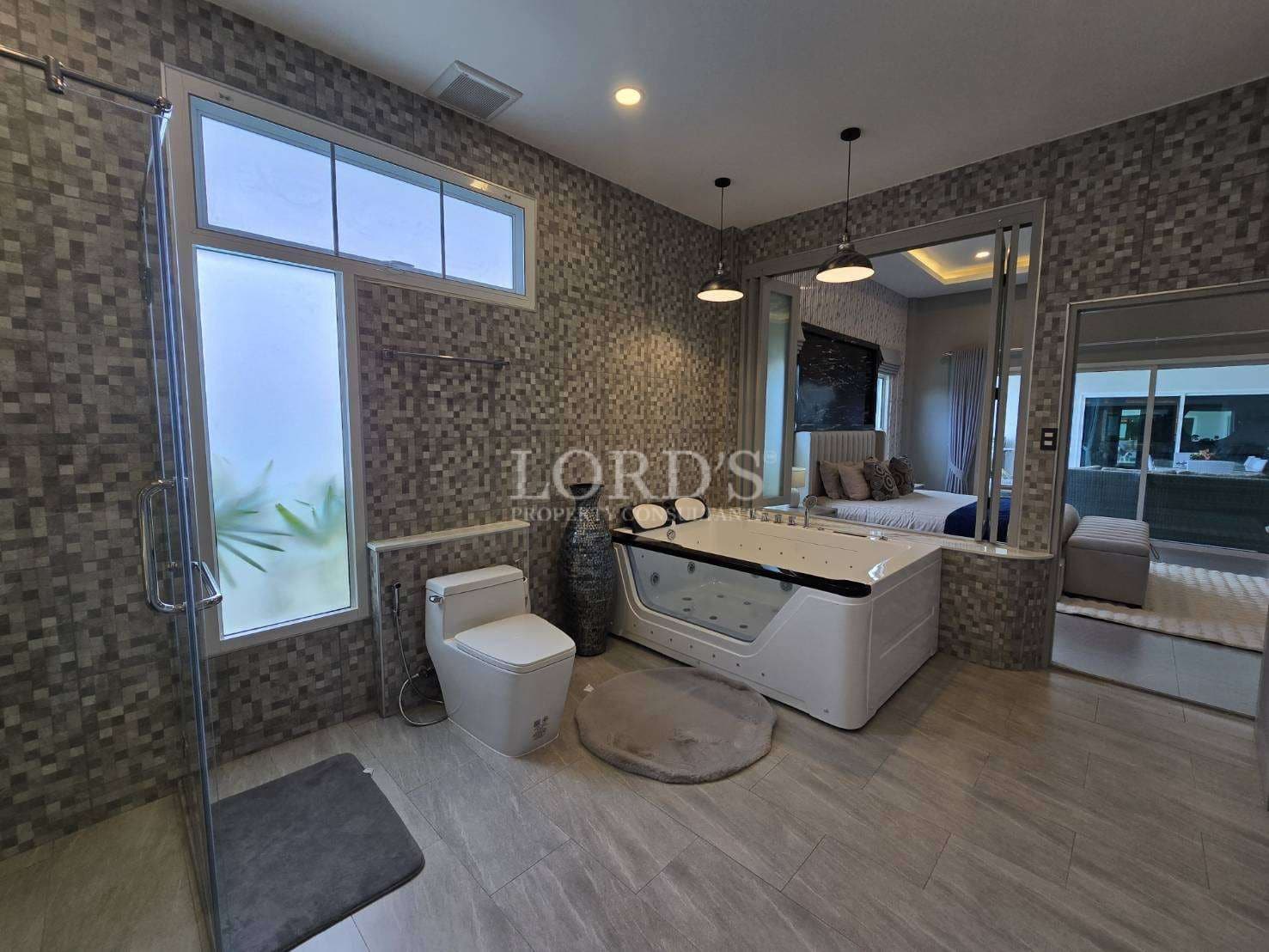 Luxury bathroom with jacuzzi bathtub, walk-in glass shower, mosaic tile walls, and modern lighting.