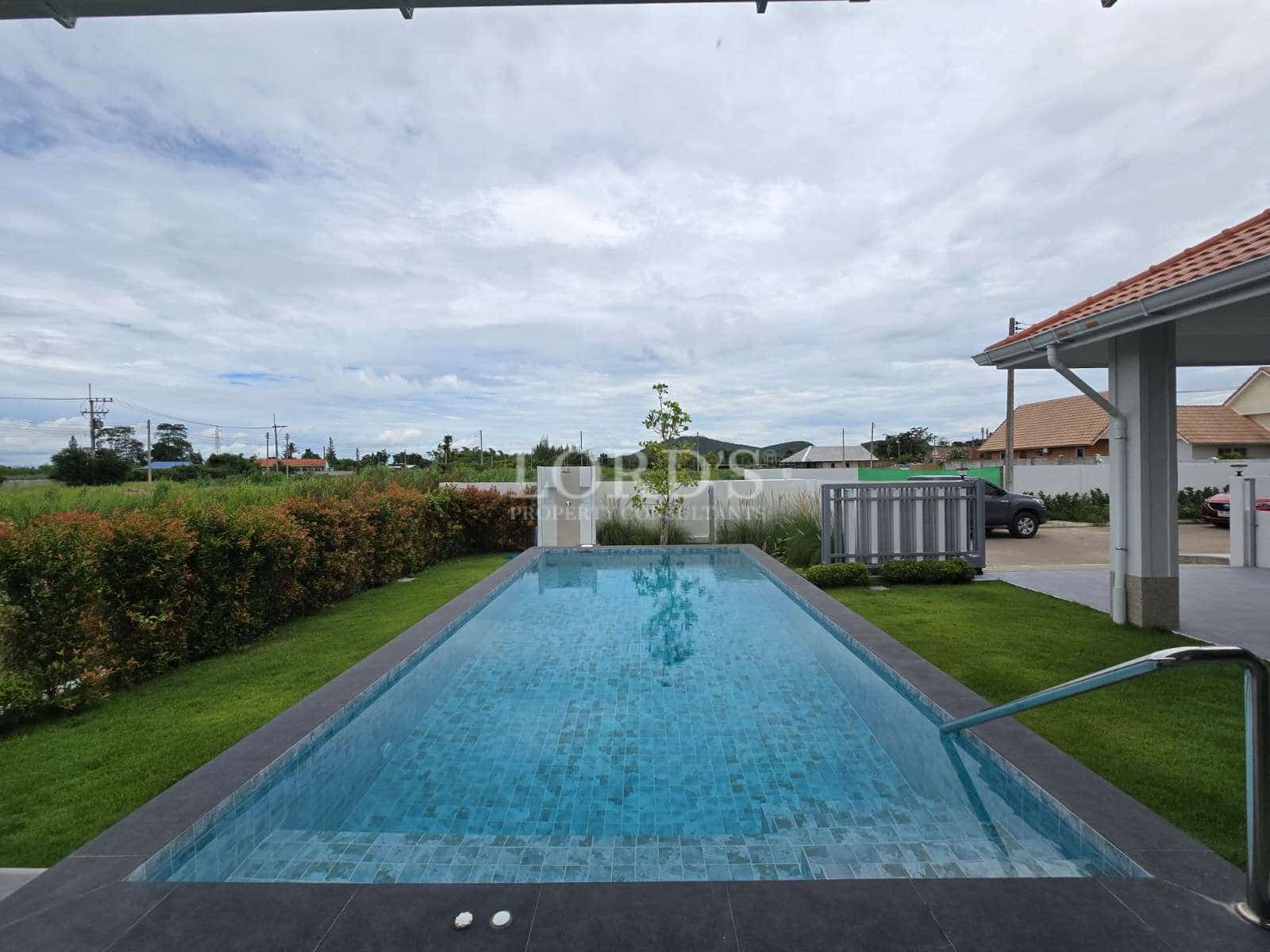 Modern pool surrounded by greenery.