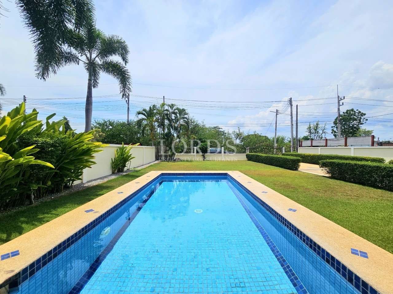 Clear pool surrounded by greenery.